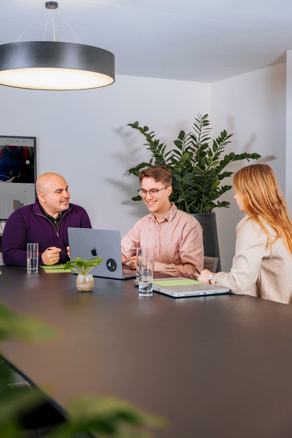 Drei Personen sitzen an einem Tisch