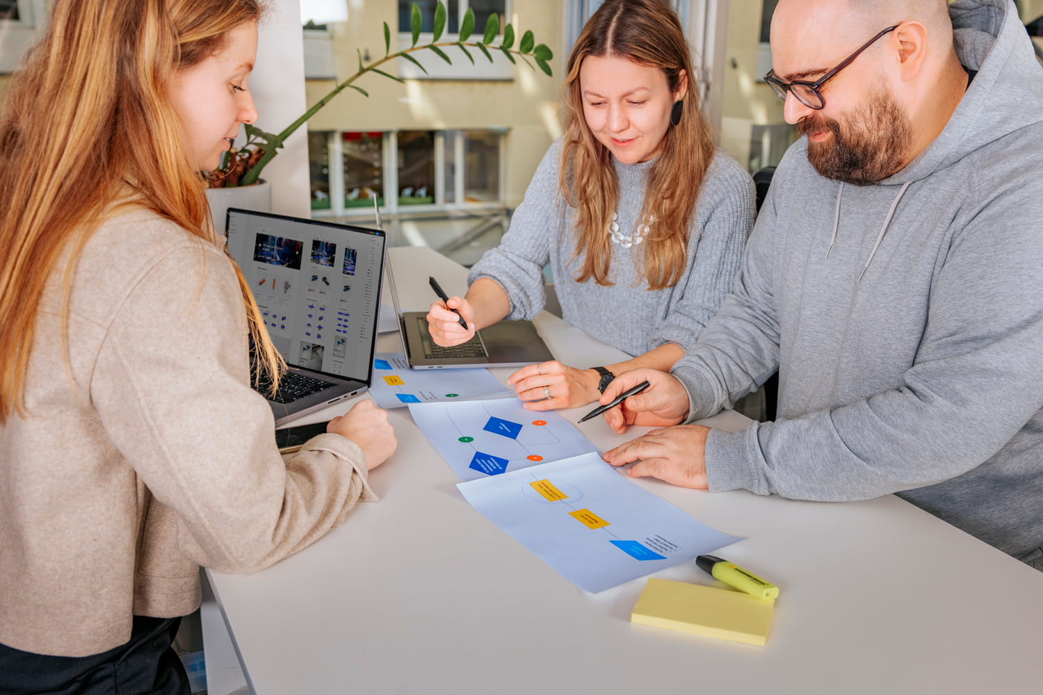 Drei Personen sitzen an einem Tisch
