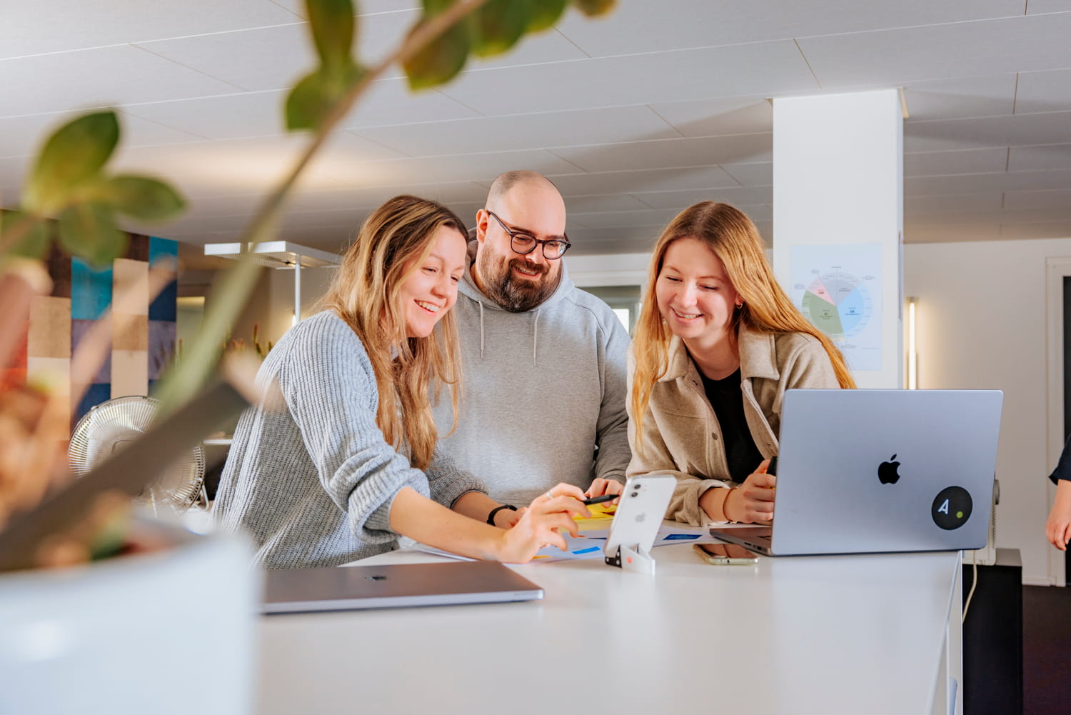 Drei Personen sitzen an einem Tisch