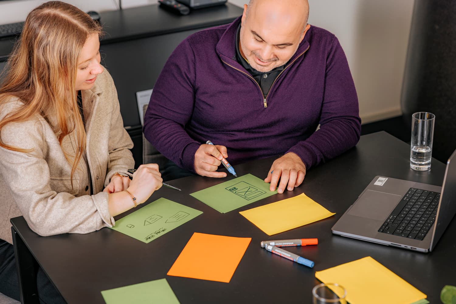Eine Frau und ein Mann arbeiten an einem gemeinsamen Projekt.