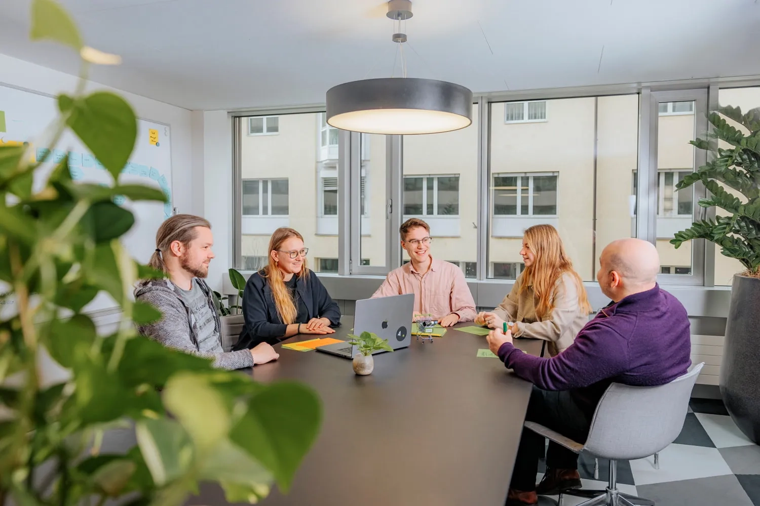 Eine Gruppe von Menschen sitzt an einem Meeting Tisch